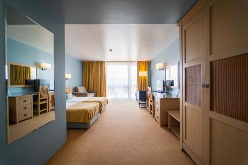 a hotel room with two beds and a desk at HVD Clubhotel Miramar - 24 Hours Ultra All Inclusive & Free Parking in Obzor