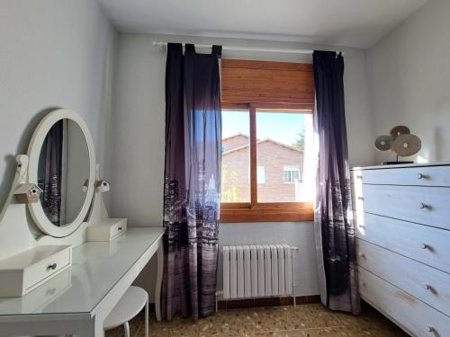 a bathroom with a window and a dresser and a mirror at "Cal Tu" in San Fausto de Campcentellas