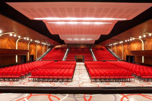 an empty auditorium with red seats and lights at Le Meridien Kochi in Cochin