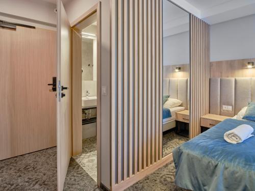 a hotel room with a bed and a bathroom at Rezydencja AMBRE in Łeba
