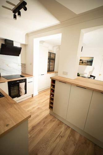 a large kitchen with white walls and wooden floors at Spacious - Sleeps 5 - Garden - Close To Sea in Gorleston-on-Sea