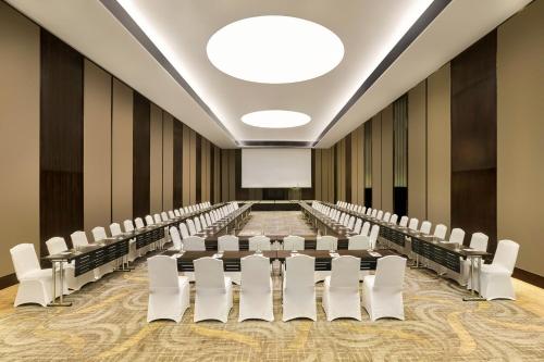 an empty conference room with white chairs and a projection screen at Sheraton Saigon Grand Opera Hotel in Ho Chi Minh City
