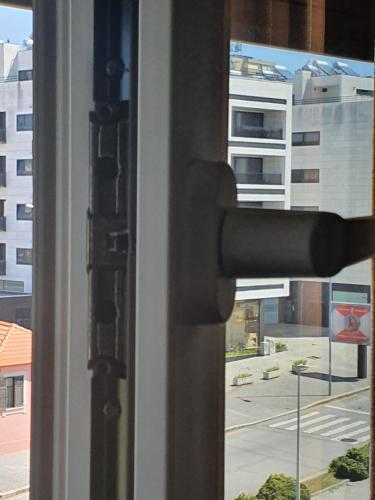 a doorhandle to a window with a view of a city at Best of nature 2, Matosinhos beach, PortoCityParc Metro! in Matosinhos