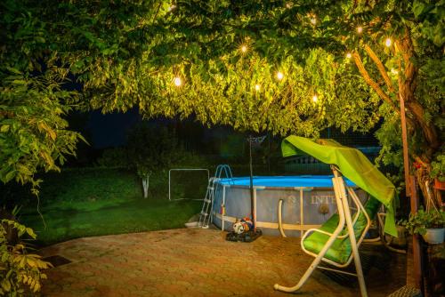 a pool in a yard with a tree and lights at Provence in Arad