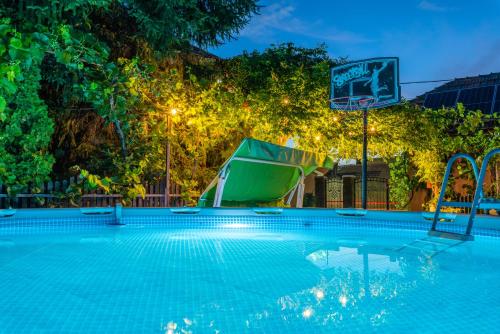 a swimming pool at night with a basketball hoop at Provence in Arad
