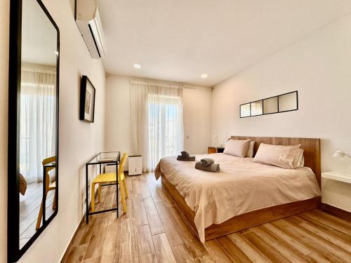 a bedroom with a large bed and a mirror at Charming retreat off the sea front in Il-Gżira