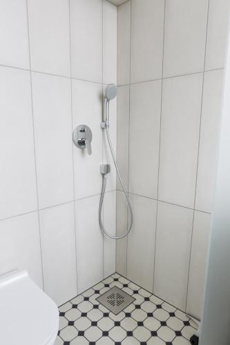 a bathroom with a shower with a tile floor at Rebeca külaliskorter in Haapsalu