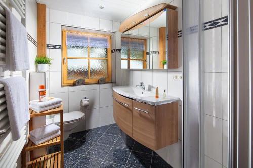 ein Badezimmer mit Waschbecken, Toilette und Spiegel in der Unterkunft Braunlehen Walch in Berchtesgaden