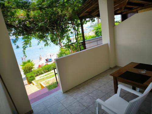 a balcony with a table and chairs and a view of the beach at Aggelika Apartments in Lithakia