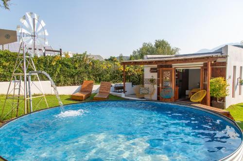 a swimming pool with a water fountain in a yard at Rus In De Rust in De Rust
