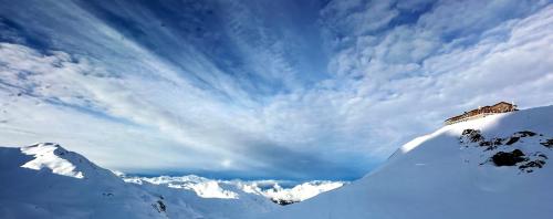 a house on top of a snow covered mountain at Ski-in Ski-out-Apartment Mountain Nest Parpan in Parpan