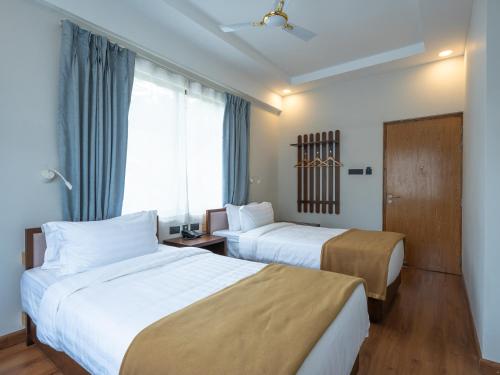 a hotel room with two beds and a window at Hotel Samye - Best Hotel In Thimphu in Thimphu