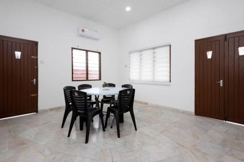 a dining room with a table and black chairs at Dream - Autumn at Pinji Ipoh Town in Ipoh