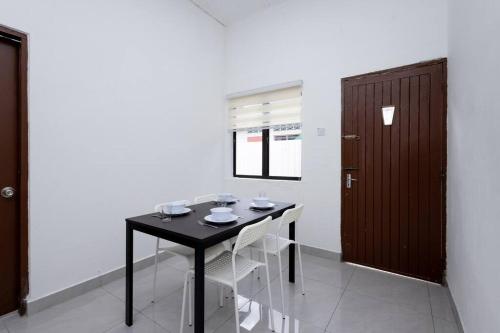 a dining room with a black table and white chairs at Dream - Autumn at Pinji Ipoh Town in Ipoh