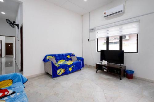 a living room with a blue couch and a tv at Dream - Autumn at Pinji Ipoh Town in Ipoh
