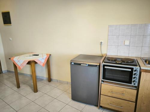 a small kitchen with a stove and a table at Aggelika Apartments in Lithakia