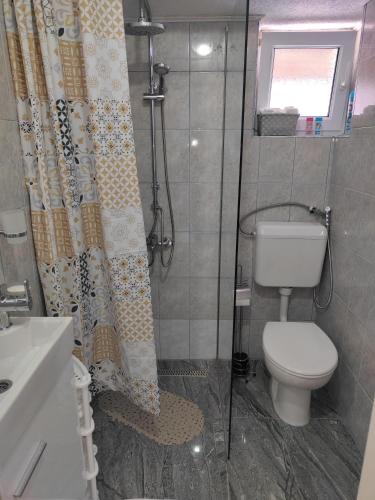 ein Badezimmer mit Dusche, Toilette und Duschvorhang in der Unterkunft Apartment Sofia in Bihać