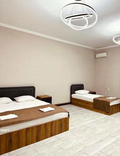 a bedroom with two beds and a ceiling at Apart Hotel in Shymkent