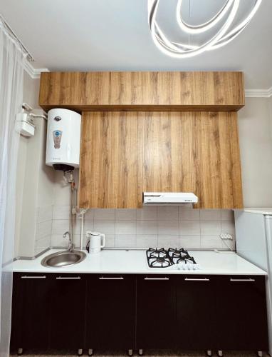 a small kitchen with a sink and a stove at Apart Hotel in Shymkent