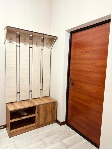 a closet with a wooden door in a room at Apart Hotel in Shymkent