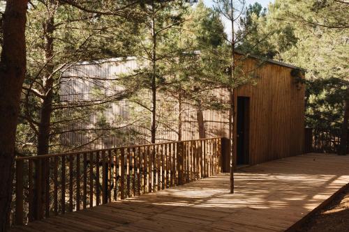 a wooden walkway with a wooden fence and trees at Noctis Hotel in Soria