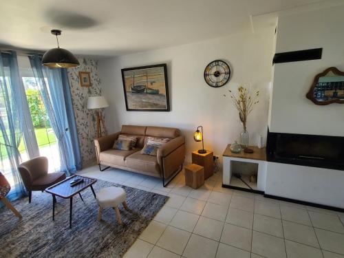 un salon avec un canapé et une télévision dans l'établissement Villa " Rosina ", à Fort-Mahon-Plage