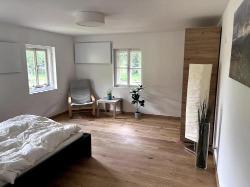 a bedroom with a bed and a chair in it at Das Detox Almhaus in Pusterwald
