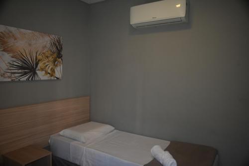 una piccola camera da letto con letto e condizionatore d'aria di Unity Hotel - Vila Mariana SP a San Paolo
