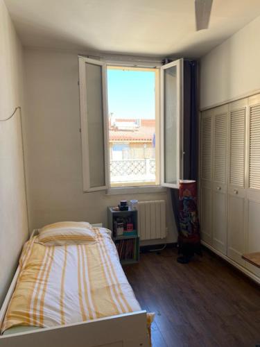 une chambre avec un lit et une grande fenêtre dans l'établissement T4 St Victor - Vieux Port, à Marseille