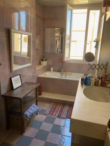 une salle de bain avec une baignoire et un lavabo et une baignoire dans l'établissement T4 St Victor - Vieux Port, à Marseille