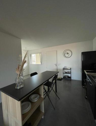 une cuisine avec une table et des chaises dans une pièce dans l'établissement Bel appart' de 47m2 au coeur de Bordeaux, à Bordeaux