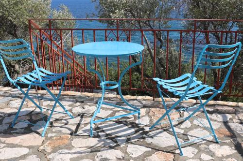 two chairs and a table and a table and two chairs at Δωμάτια Κόκκινος Πύργος in Plomarion