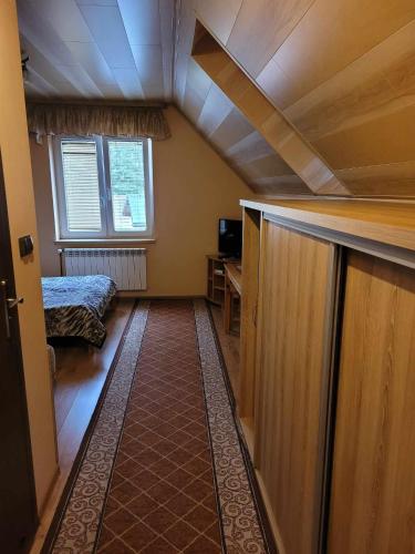 a room with an attic with a bed and a window at Jelonek Zawoja in Zawoja