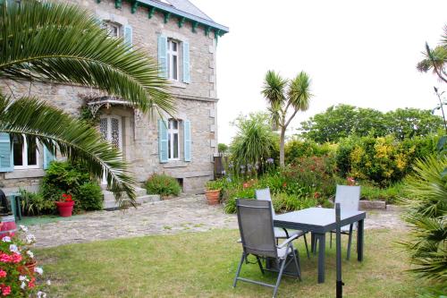 a table and chairs in front of a house at La Maison du Port, vue mer, jardin et parking in Roscoff