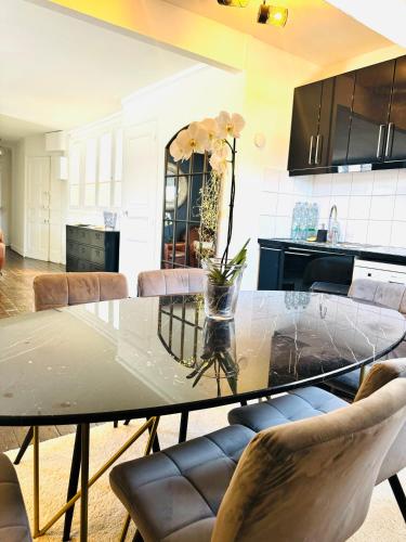 une table de salle à manger avec un vase de fleurs dessus dans l'établissement Smart Normandie, à Deauville