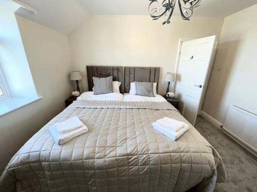 a bedroom with a large bed with two towels on it at Orme Villa, Hot Tub, Llandudno, Stunning Views , sleeps 12 in Llandudno