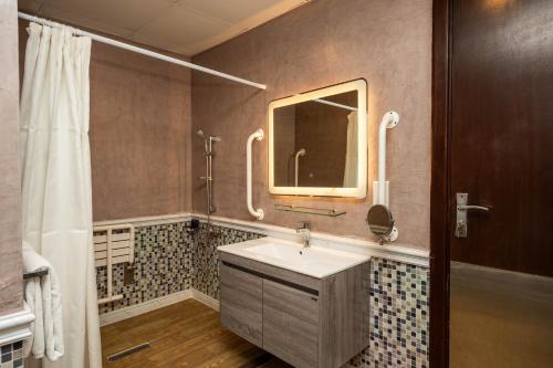 un bagno con lavandino e specchio di Ezdan Hotel, Residences a Doha