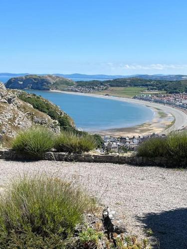 a view of a beach and a body of water at Orme Villa, Hot Tub, Llandudno, Stunning Views , sleeps 12 in Llandudno