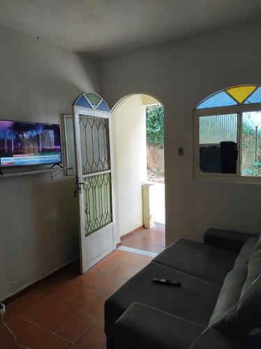 a living room with a couch and two stained glass windows at Refugio dos viajantes in Piraí
