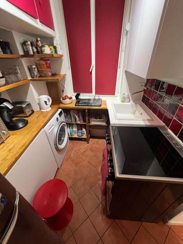 une cuisine avec une machine à laver et un évier dans l'établissement Appartement central Paris, à Paris
