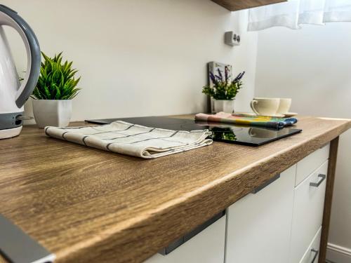 a kitchen counter with a wooden counter top at Villa Blue City Apartman in Szekszárd