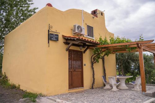 a small yellow building with a door and a table at Vesuvio Inn Guest House e Wine Experience in Boscotrecase