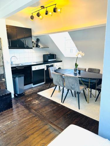 une cuisine et une salle à manger avec une table et des chaises dans l'établissement Smart Normandie, à Deauville