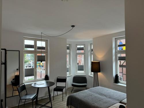a bedroom with a bed and a table and chairs at Apartmenthaus Buxtehude St -Petri-Platz Apt 2 in Buxtehude