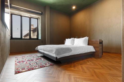 a bedroom with a bed and a large window at Castel Mimi Wine Resort in Bulboaca