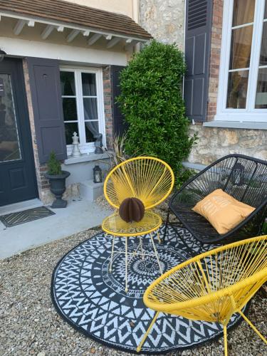 deux chaises jaunes et une table avec un ballon dessus dans l'établissement Hébergement à Everly, à Éverly