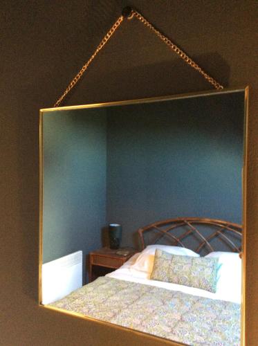 a mirror reflecting a bed in a bedroom at La Mardelle in Saint-Gervais-la-Forêt