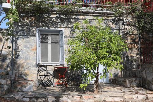 a window and a tree in front of a building at Δωμάτια Κόκκινος Πύργος in Plomarion