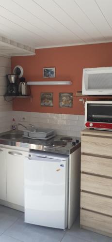 Il comprend une cuisine équipée d'une cuisinière et d'un réfrigérateur blanc. dans l'établissement L'ARDOISINE, à Sevremont