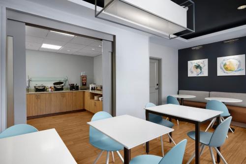 a room with tables and chairs and a kitchen at TownePlace Suites by Marriott Columbia Northwest/Harbison in Columbia